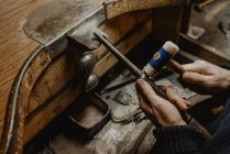 Anonimo orafo martellare ed espandere anello vuoto su bastone di metallo mentre si lavora in officina — Foto stock
