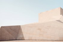 Design esterno della moderna costruzione in calcestruzzo con pareti angolari geometriche contro il cielo blu — Foto stock