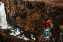 Жінка в окулярах між дикими землями з водоспадом — стокове фото