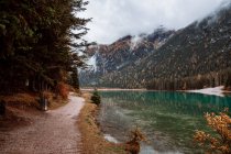 Sentiero vicino al lago con montagne nebbiose — Foto stock