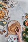 Vue du dessus d'une femme anonyme préparant des desserts pour Noël à une table avec des décorations de Noël — Photo de stock