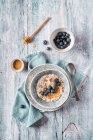 Köstliche frische Haferbrei über Nacht mit Blaubeeren und Sahne auf Küchentuch auf hölzernem Tisch — Stockfoto