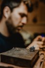 Unbekannter Juwelier mit professioneller Poliermaschine auf Werkbank bei Herstellung von Metallring in Werkstatt — Stockfoto