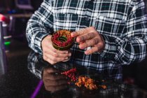 Cropped unrecognizable man hands preparing a bowl for hookah in a night club — Stock Photo