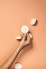 Crop donna irriconoscibile con manicure e pelle delicata dimostrando tampone di cotone pulito su sfondo beige — Foto stock