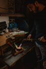 Goldschmied schmilzt im Stehen neben Werkbank in Werkstatt Metall für Schmuck mit Blaslampe — Stockfoto