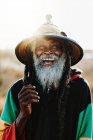 Ritratto di allegro vecchio rastafari etnico con dreadlocks guardando la fotocamera nella natura con sfondo bianco — Foto stock
