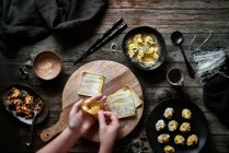 Vista dall'alto di una donna anonima che prepara zuppa wonton su un tavolo di legno — Foto stock