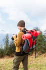 Vue latérale du randonneur féminin prenant des photos du paysage montagneux pendant le voyage — Photo de stock