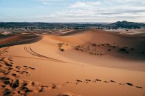 From above of colorful empty desert with big dunes under cloudy blue sky in Morocco — Stock Photo