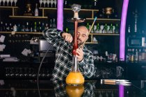 Uomo che prepara narghilè tradizionale in un night club — Foto stock