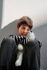 Самотній дев'ятнадцятирічний хлопчик жертва домашнього насильства, що сидить на підлозі і приймає іграшку — стокове фото