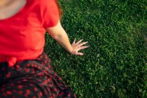 Врожай Транквіль жінка сидить на траві на лузі в парку і насолоджується заходом сонця влітку — стокове фото