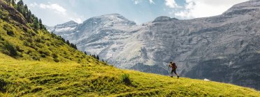 Vista lateral panorámica de hombres irreconocibles senderismo montaña verde en los Dolomitas, Italia - foto de stock