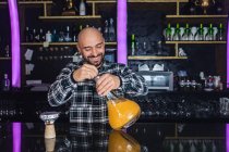 Happy man preparing a big glass traditional hookah in a night club — Stock Photo
