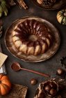 De cima bolo de abóbora apetitoso saboroso com nata de chocolate na mesa decorada com verduras de outono — Fotografia de Stock