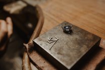 Fechar pedra preciosa azul brilhante para jóias colocadas em placa de metal na bancada de madeira — Fotografia de Stock