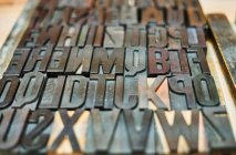 Ensemble de lettres et de chiffres de presse-lettres minables en métal placés dans une boîte en bois en typographie — Photo de stock