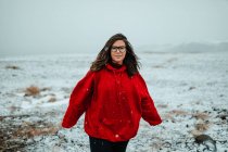Junger fröhlicher Tourist in Brille mit stechenden Blicken in die Kamera zwischen menschenleerem Boden im Schnee — Stockfoto
