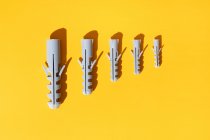 Top view of plastic dowels of different sizes with holes on ribbed surface in row — Stock Photo