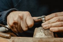 Hände eines anonymen männlichen Goldschmieds formen Metallring in Werkstatt mit manuellem Werkzeug — Stockfoto