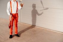Cropped unrecognizable skilled young male circus performer juggling with club on modern building — Stock Photo