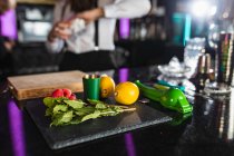Menta, limones, frambuesa y utensilios en una mesa de bar para preparaciones de cócteles - foto de stock