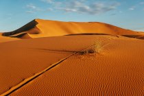 Вище кольорової порожньої пустелі з великими дюнами під хмарним блакитним небом у Марокко. — стокове фото