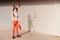 Skilled young male circus performer juggling with club on modern building — Stock Photo