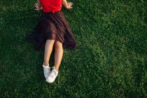 Врожай Транквіль жінка сидить на траві на лузі в парку і насолоджується заходом сонця влітку — стокове фото