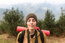 Carefree female backpacker standing in highlands with closed eyes and enjoying nature during travel in summer — Stock Photo