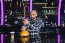 Man preparing a big glass traditional hookah in a night club — Stock Photo