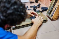 Unerkennbarer männlicher Meister bei der Arbeit mit Metallbuchstaben am Tisch in der Buchdruckerei — Stockfoto