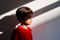 Вид збоку сумного безпорадного чотирнадцятирічного хлопчика з синцями на обличчі, який страждає від домашнього насильства — стокове фото