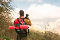 Vue arrière d'une randonneuse anonyme photographiant un paysage montagneux pendant un voyage — Photo de stock