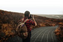 Вид ззаду молодого туриста на прогулянці фотографії долини з пагорба і хмарного неба — стокове фото