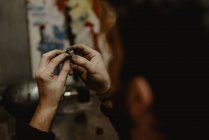 Невпізнаваний ювелір з використанням професійної полірувальної машини на верстаті при виготовленні металевого кільця в майстерні — стокове фото