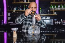 Mann bereitet in Nachtclub ein großes Glas traditionelle Wasserpfeife zu — Stockfoto
