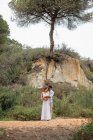 Noiva diversa feliz e noivo abraçando enquanto está na floresta no dia do casamento — Fotografia de Stock