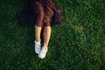 Raccolto Tranquillo femminile seduto sull'erba sul prato nel parco e godersi il tramonto in estate — Foto stock