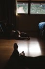 Молода татуйована стогін жінка в нижній білизні відпочиває на землі в темряві — стокове фото