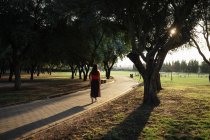 Mulher na moda em roupa de verão em pé no caminho no jardim — Fotografia de Stock