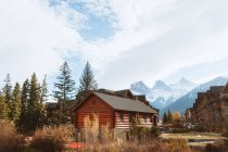 Malerische herbstliche Landschaft mit Holzhäusern in Flussnähe und schneebedeckten Bergen in der Stadt Canmore in der Nähe des Banff National Park in Kanada — Stockfoto