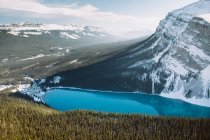 Desde arriba limpio Lago Louise con agua azul brillante situado cerca de las montañas nevadas en el día de invierno en Alberta, Canadá - foto de stock