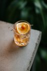 Склад холодного крижаного віскі, прикрашеного лимонним шматочком і поміщеного на бетонний стіл — стокове фото