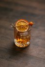 From above composition of cold icy whiskey garnished with lemon slice and placed on wooden table — Stock Photo