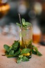 Cocktail de mojito froid à base de limette de rhum et de feuilles de menthe servi avec glaçons et paille réutilisable — Photo de stock