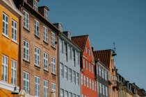 From below of bright brick and stone apartment buildings against cloudless blue sky in Copenhagen — Stock Photo