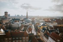 Сверху внешняя часть города с асфальтированной дорогой с транспортом и пешеходами между старой архитектурой Копенгагена — стоковое фото
