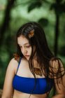 Ruhige junge Frau im Bikini mit Zierschmetterlingen an Körper und Haaren vor verschwommenem grünen Laub beim Sommerabenteuer in Costa Rica — Stockfoto